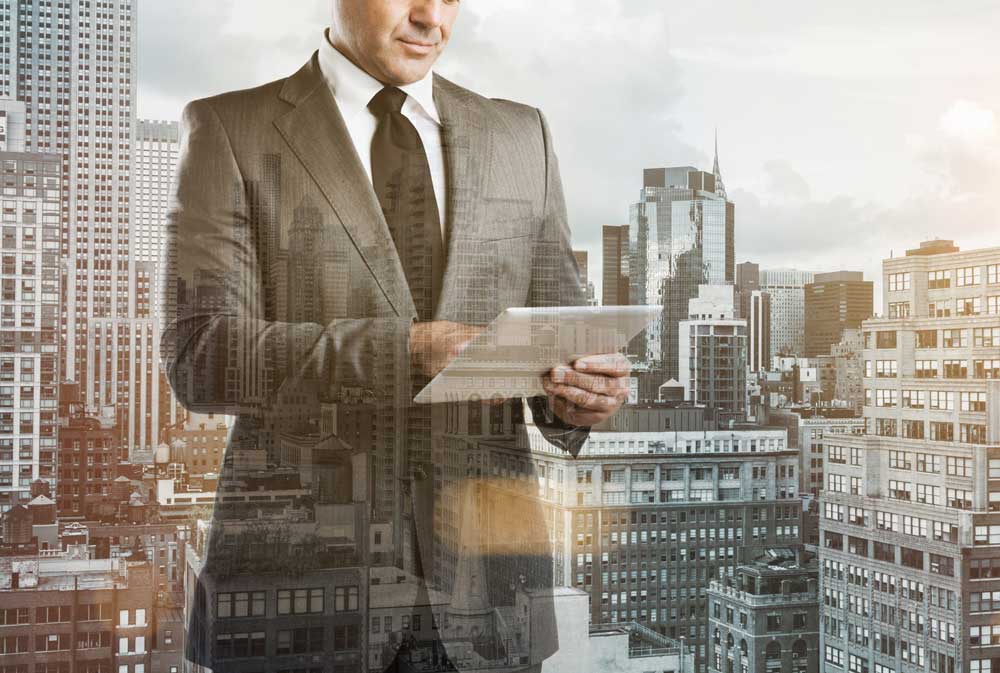 semi transparent business owner professional using laptop with building background